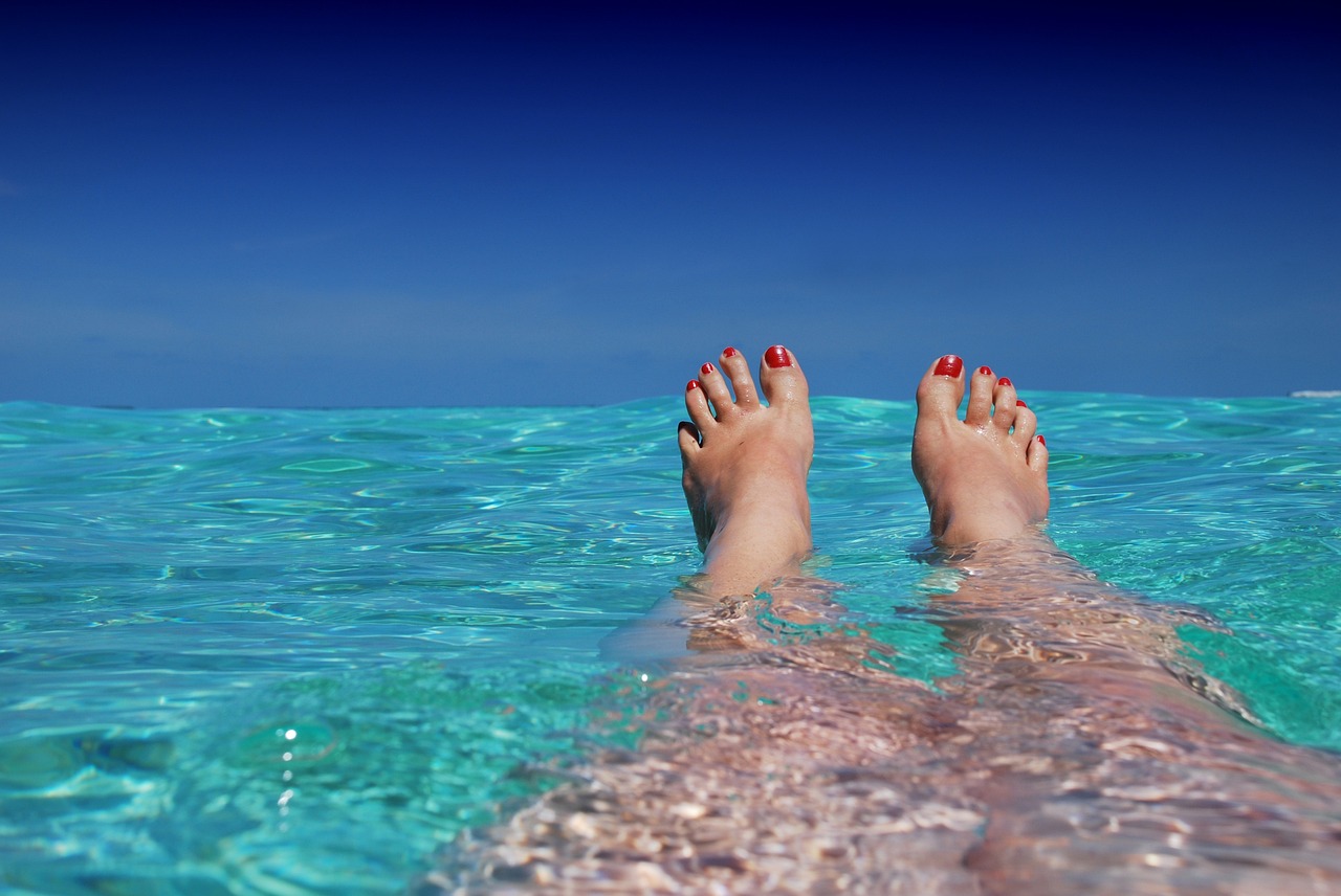 piedi di ragazza nel mare delle maldive una delle migliori destinazioni per le vacanze