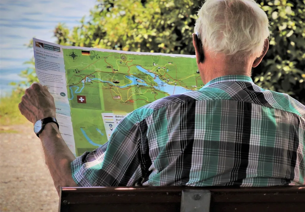un anziano che controlla una mappa. con gli investimenti alternativi ai fondi pensione sarete liberi di viaggiare